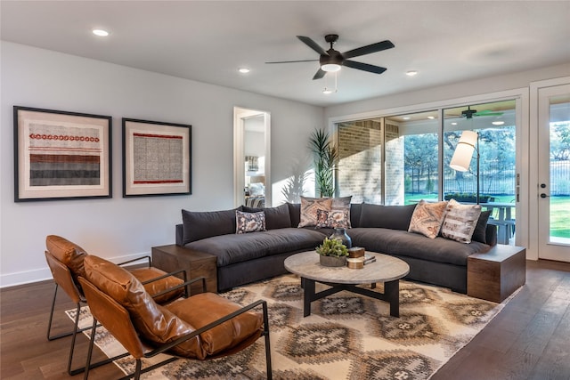 living room with dark wood-type flooring, ceiling fan, and plenty of natural light