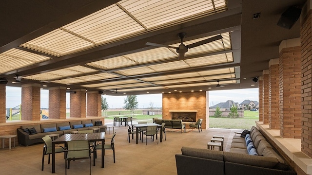 view of patio / terrace featuring ceiling fan and an outdoor living space with a fireplace