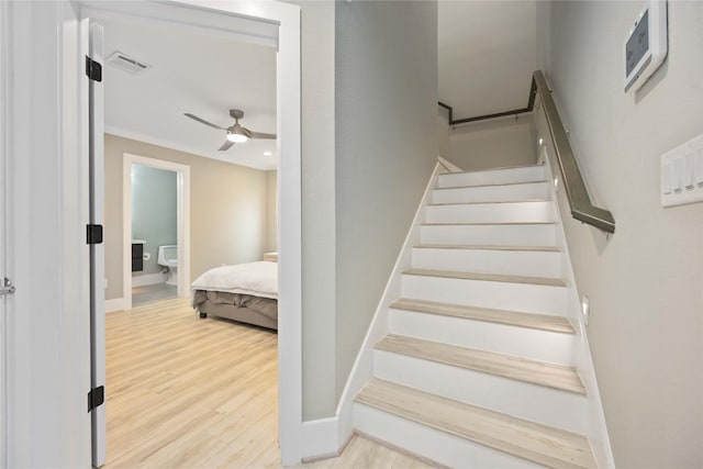 staircase with ceiling fan and hardwood / wood-style floors