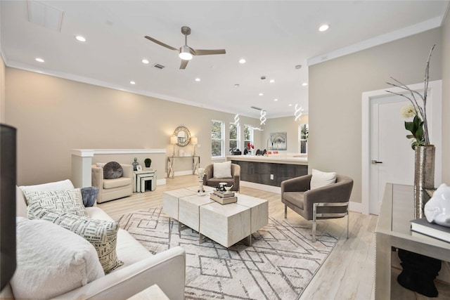 living room with ceiling fan, crown molding, and light hardwood / wood-style flooring