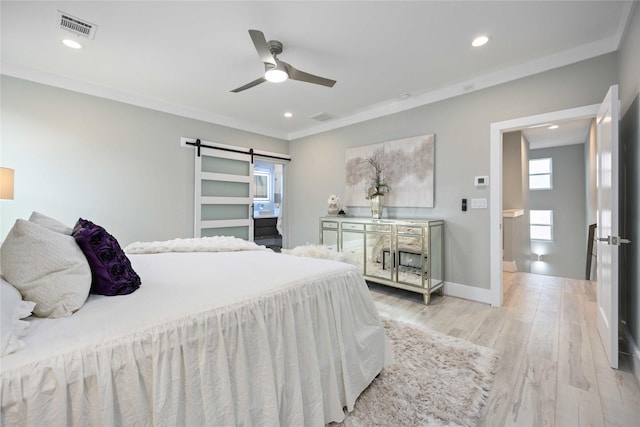 bedroom with ceiling fan, light hardwood / wood-style flooring, ornamental molding, and a barn door