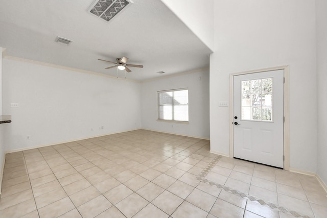 tiled entrance foyer with ornamental molding, ceiling fan, and a wealth of natural light