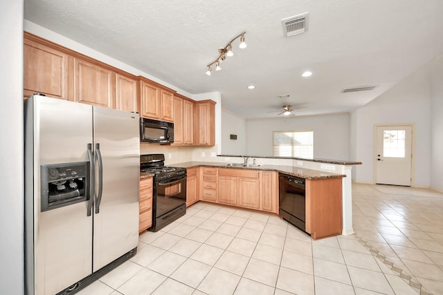 kitchen featuring ceiling fan, light tile patterned floors, kitchen peninsula, stone countertops, and black appliances