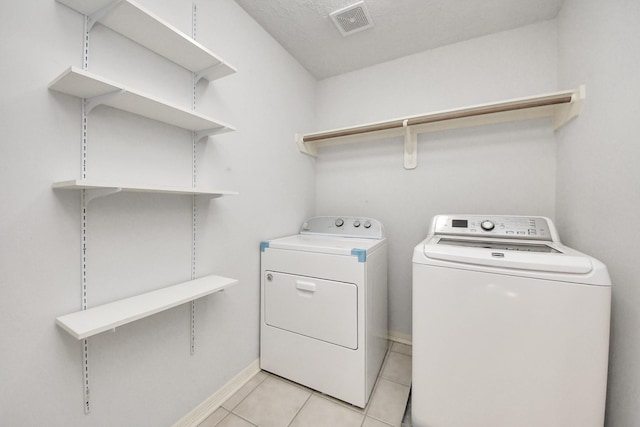 washroom with washing machine and dryer and light tile patterned floors