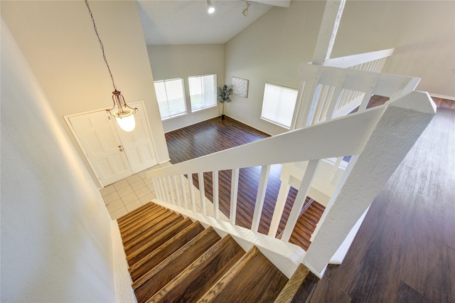 staircase featuring high vaulted ceiling