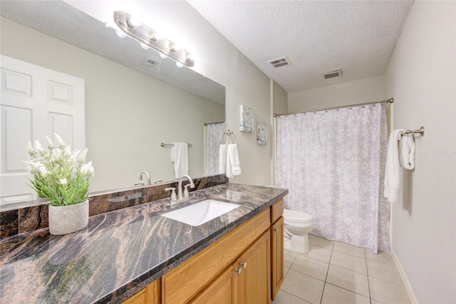 bathroom featuring a textured ceiling, tile patterned floors, vanity, and toilet