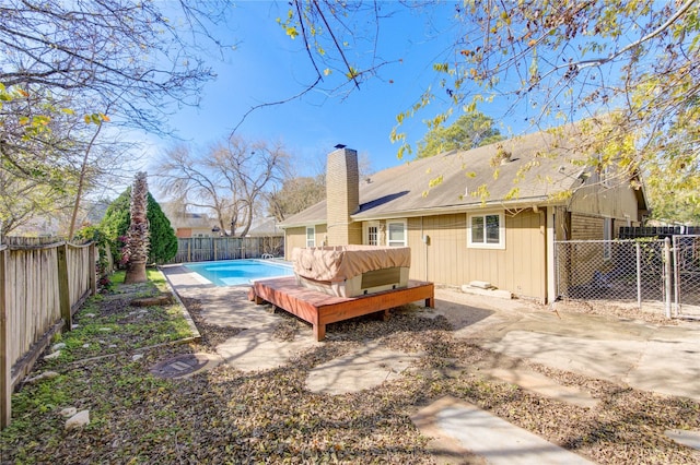 back of house with a fenced in pool