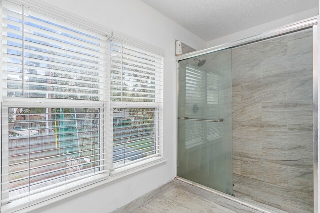 bathroom with a textured ceiling and plenty of natural light