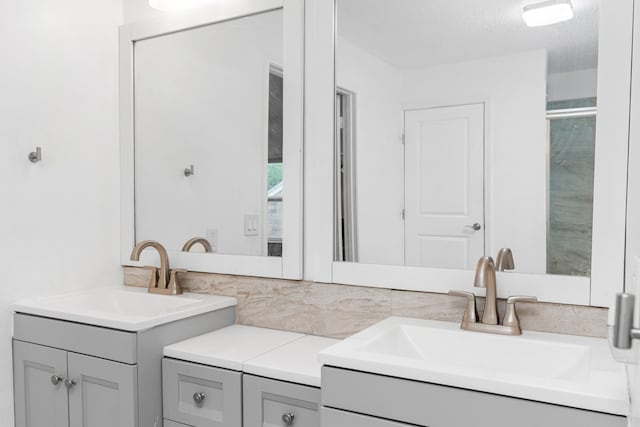 bathroom with a textured ceiling, backsplash, and vanity