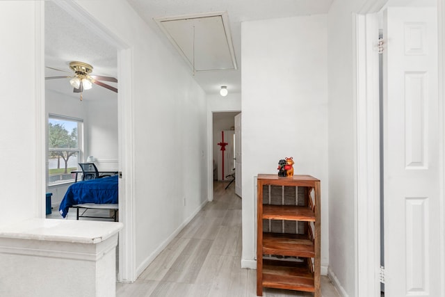 hallway featuring a textured ceiling and light wood-type flooring