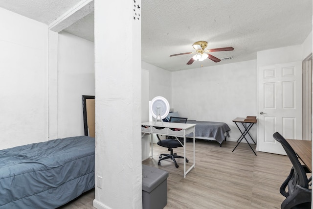 bedroom featuring a textured ceiling, ceiling fan, and light hardwood / wood-style flooring