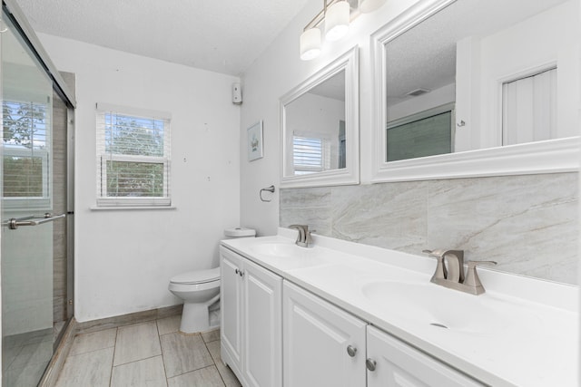 bathroom with toilet, a textured ceiling, walk in shower, tile patterned floors, and vanity