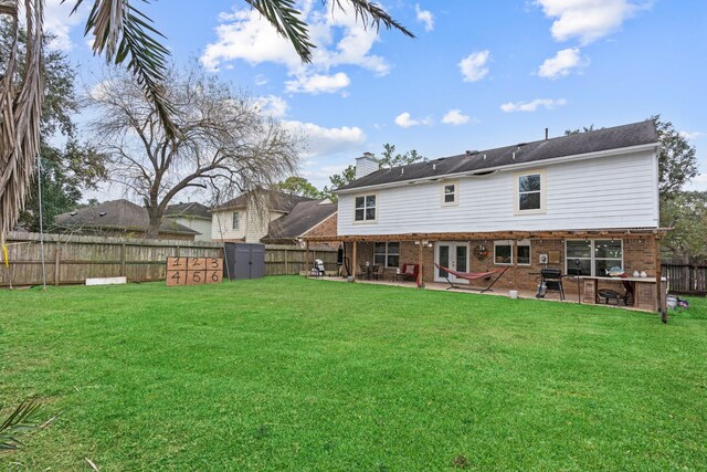 back of property with a lawn and a patio area