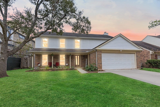 front facade featuring a garage and a yard