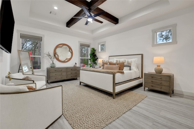 bedroom with coffered ceiling, light wood-type flooring, ceiling fan, multiple windows, and beam ceiling