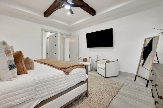 bedroom with ceiling fan, beamed ceiling, and light hardwood / wood-style flooring