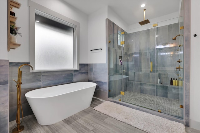 bathroom with tile walls and independent shower and bath