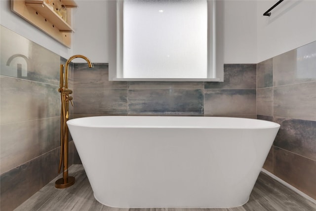 bathroom with tile walls and a tub to relax in