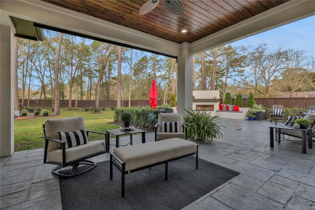 view of patio / terrace featuring ceiling fan and an outdoor living space with a fireplace