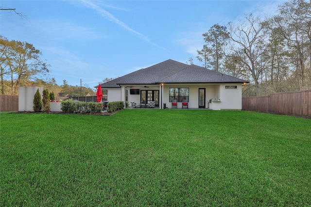 rear view of property featuring a lawn and a patio