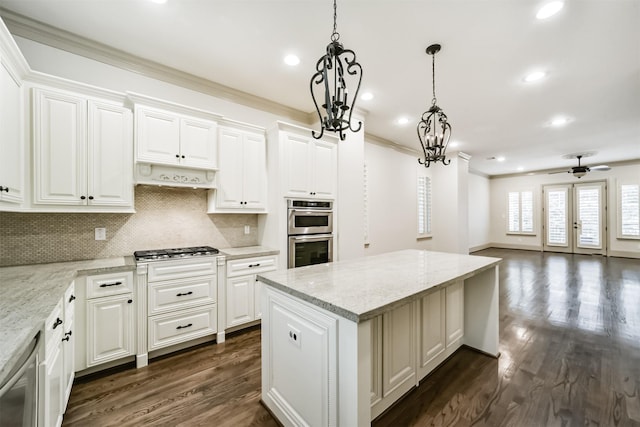 kitchen with ceiling fan with notable chandelier, white cabinetry, light stone counters, and appliances with stainless steel finishes