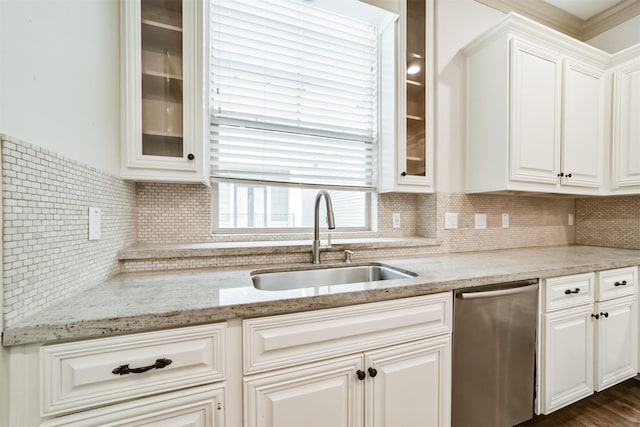 kitchen featuring white cabinets, dishwasher, light stone countertops, sink, and backsplash