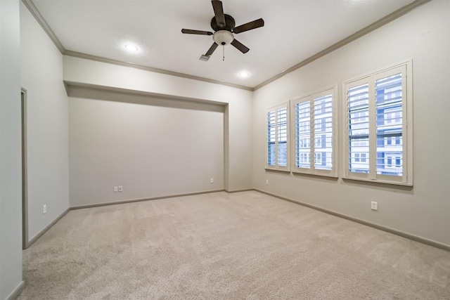 unfurnished room featuring light colored carpet, ceiling fan, and crown molding