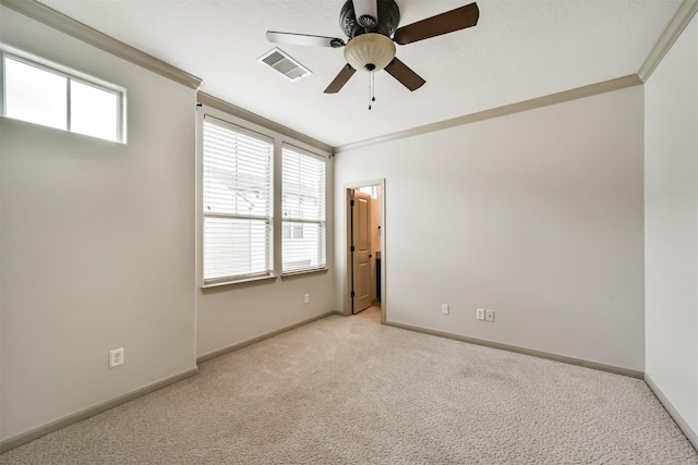 spare room featuring light colored carpet, ceiling fan, and ornamental molding