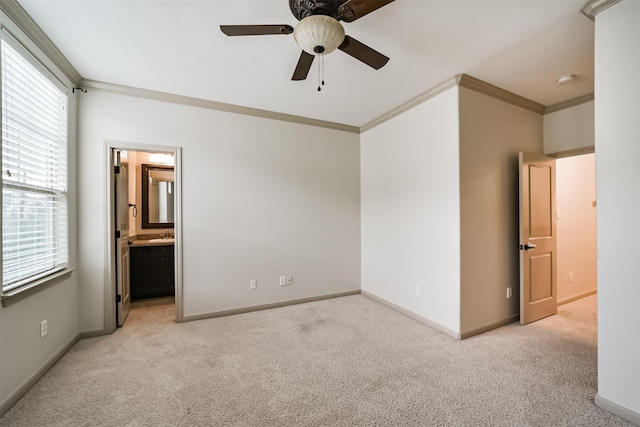 unfurnished bedroom with ensuite bath, ceiling fan, crown molding, and light colored carpet