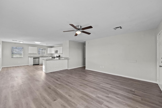 unfurnished living room featuring ceiling fan, sink, and wood-type flooring