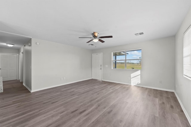 unfurnished room featuring visible vents, baseboards, and wood finished floors