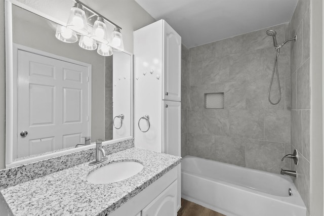 bathroom featuring wood finished floors, bathtub / shower combination, and vanity