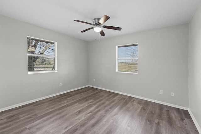 spare room featuring ceiling fan, baseboards, and dark wood-type flooring