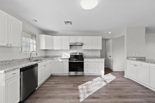 kitchen with visible vents, appliances with stainless steel finishes, white cabinets, a sink, and under cabinet range hood