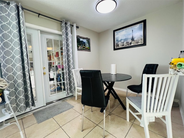 dining area featuring a textured ceiling and tile patterned floors