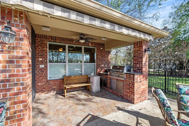 view of patio with an outdoor kitchen, ceiling fan, and a grill