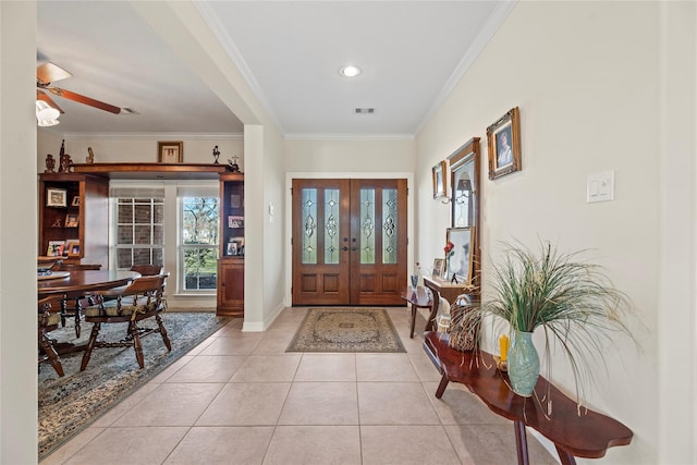 foyer featuring french doors, light tile patterned flooring, ornamental molding, and ceiling fan