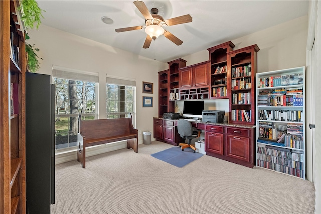 carpeted office space with ceiling fan