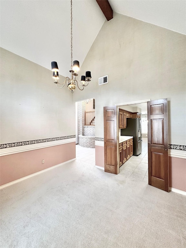 unfurnished living room featuring high vaulted ceiling, a notable chandelier, light carpet, and beamed ceiling