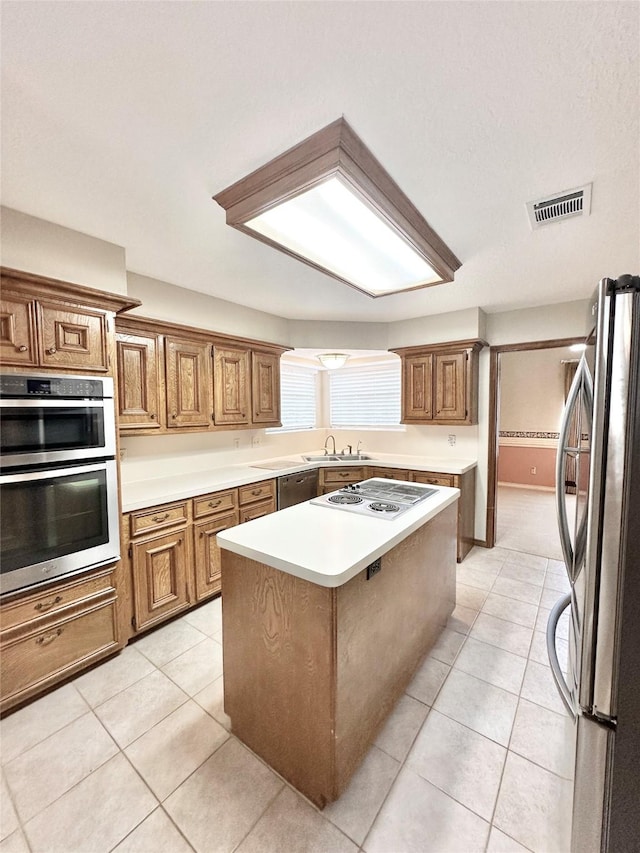 kitchen with a kitchen island, a kitchen bar, light tile patterned floors, and appliances with stainless steel finishes