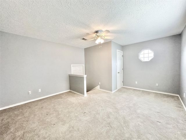 empty room with a textured ceiling, ceiling fan, and carpet