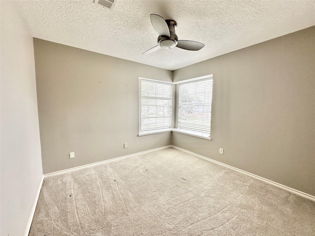 unfurnished room with ceiling fan, light colored carpet, and a textured ceiling