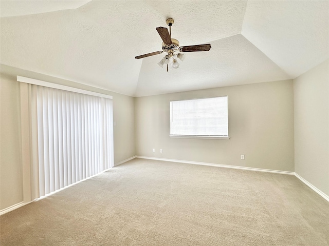 empty room with lofted ceiling, ceiling fan, and carpet