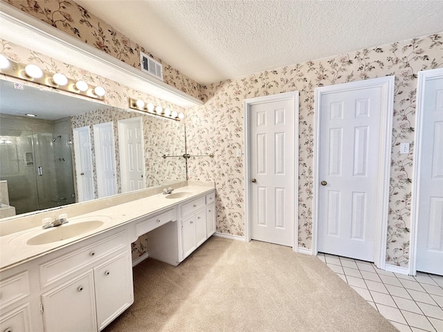 bathroom with vanity, walk in shower, tile patterned floors, and a textured ceiling