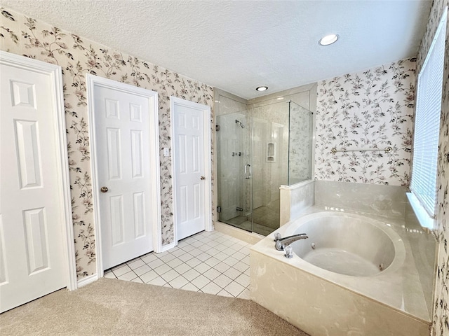 bathroom with a textured ceiling, independent shower and bath, and tile patterned floors