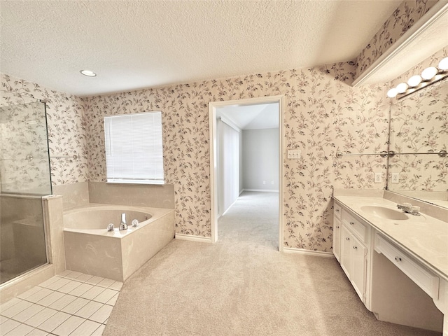 bathroom with a textured ceiling, independent shower and bath, and vanity