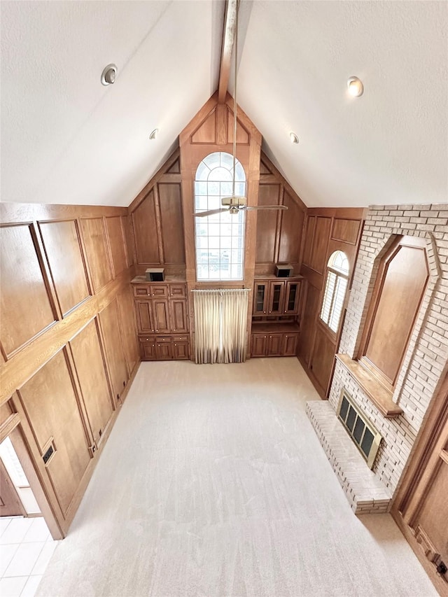 additional living space featuring a brick fireplace, wooden walls, light carpet, and lofted ceiling