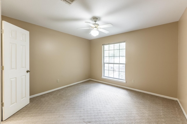 carpeted spare room featuring ceiling fan