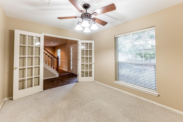 carpeted spare room featuring ceiling fan and french doors