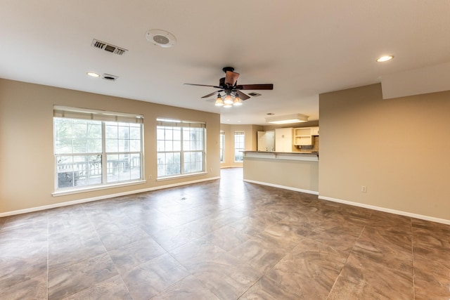 unfurnished living room with ceiling fan and a wealth of natural light